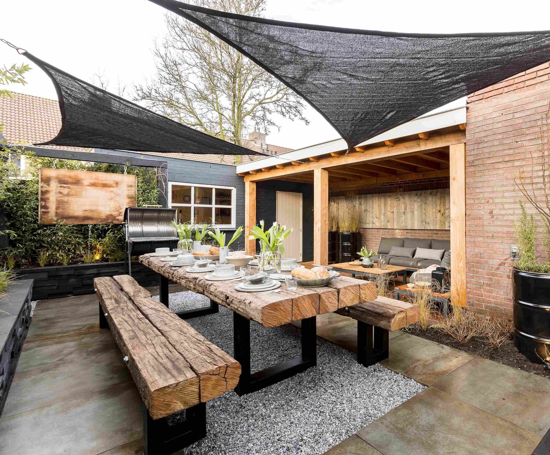 Sfeervolle tuininrichting met overkapping, tuinmeubelen en beplanting